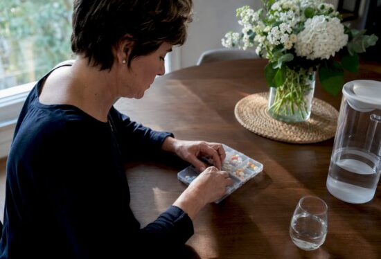 Caregiver organizing pills in pillbox